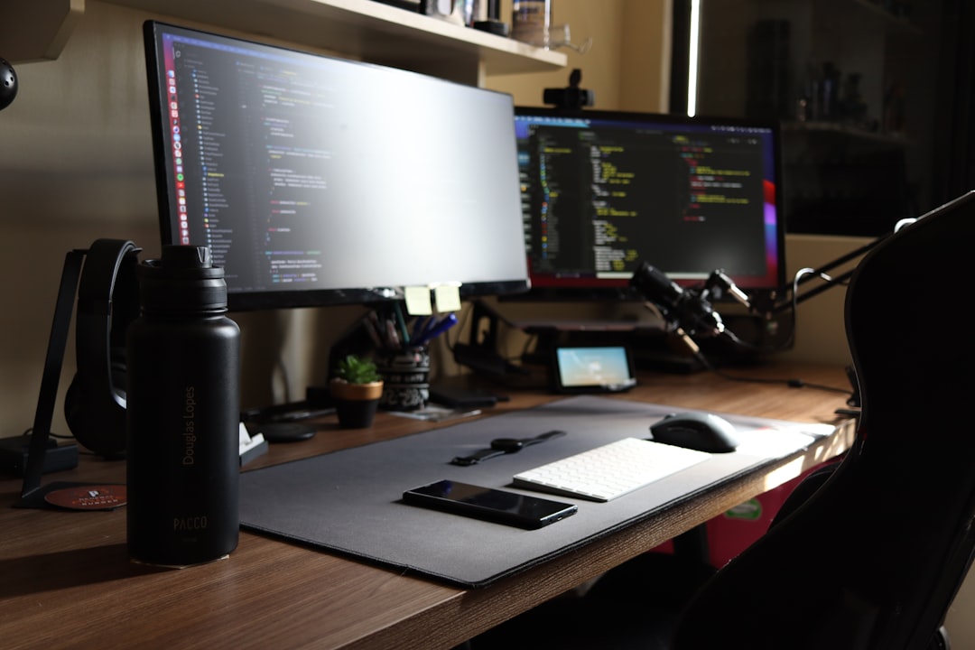 a computer desk with two monitors and a mouse